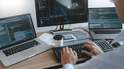 programmer working on computer in it office typing data coding in software and checking code on comp