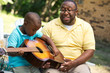 © digitalskillet1 - Father teaaching his his son to play the guitar.