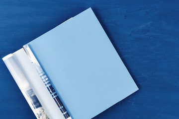 Canvas Print - Top view of open magazine page with copy space on classic blue background