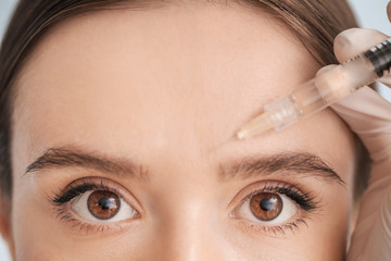 Wall Mural - Young woman receiving filler injection, closeup