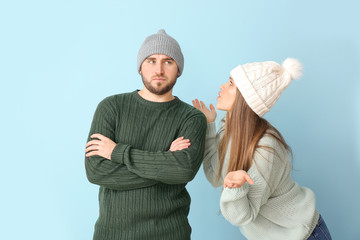 Wall Mural - Portrait of emotional couple in winter clothes on color background