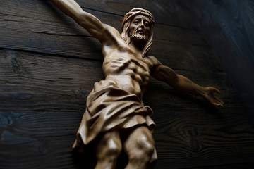  Cruciefied Jesus figure isolated on rustic dark brown table.