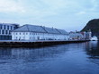 White building in european Alesund town reflected in water in Norway