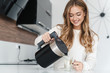 Photo of beautiful happy woman smiling and making tea