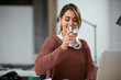© JustLife - Young businesswoman drinking water in office
