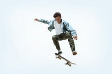 Caucasian Young Skateboarder Riding Isolated On A White Studio Background. Man In Casual Clothing Training, Jumping, Practicing In Motion. Concept Of Hobby, Healthy Lifestyle, Youth, Action, Movement.