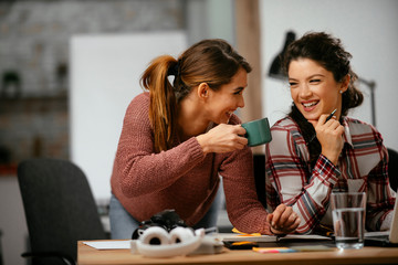 Two women working together.  Beautiful colleagues working on project. 