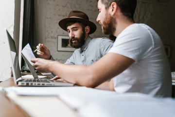 Wall Mural - Image of caucasian young businesslike men working together at office