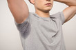 cropped view of young man in grey t-shirt with sweaty underarm isolated on grey