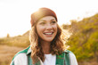 Leinwandbild Motiv Image of young woman wearing hat and plaid shirt walking outdoors