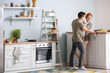© Pixel-Shot - Happy couple cooking together in kitchen