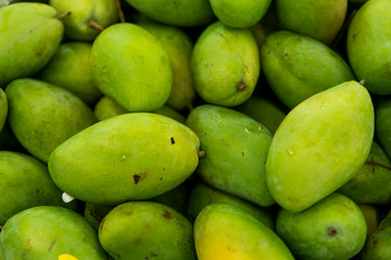 Texture of green juicy fresh mango fruit. Group of fresh green mango for sell .Thai fruit tropical raw mangoes. Tropical and exotic fruits. Healthy and vitamin food concept.