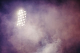 Fototapeta Sport - stadium lights and smoke against dark night sky background