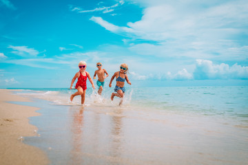 Wall Mural - happy kids enjoy beach vacation, boy and girls have fun