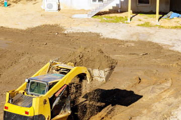 Bulldozer moving, leveling ground at construction site