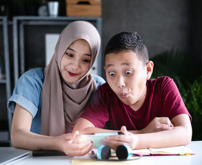 two muslim students look with surprise,while using mobile phone,at classroom,blurry light around,Lens flare effect