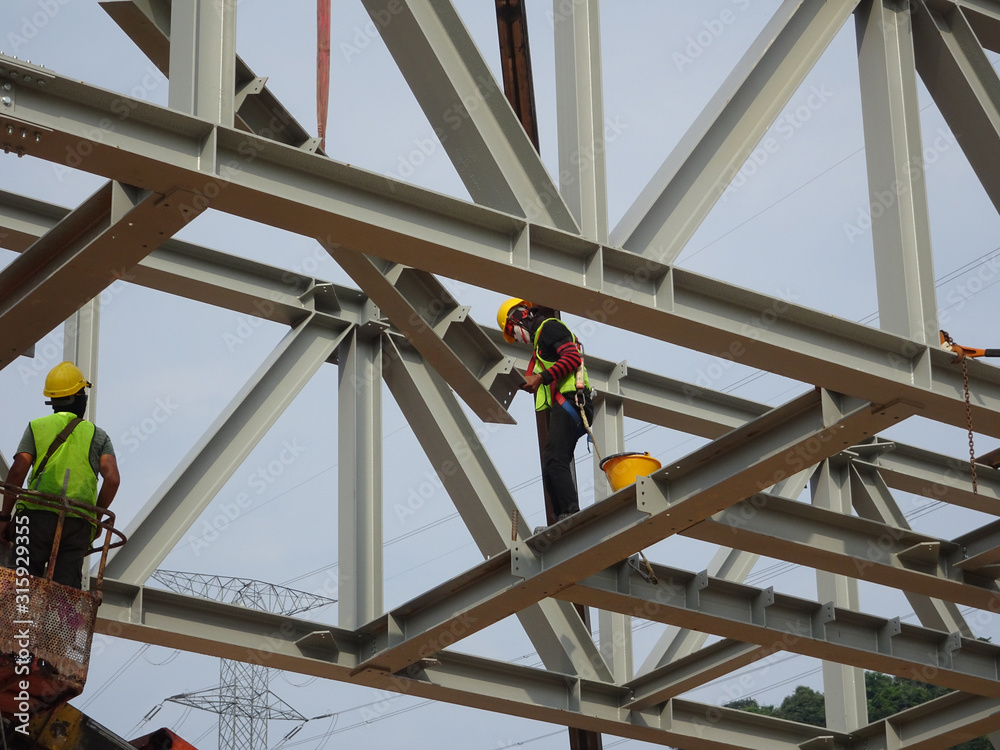 Construction workers working at height installing the steel structure ...