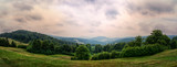 Fototapeta Na sufit - Wide panorama of an idyllic mountain landscape on a cloudy day (photomerge image)