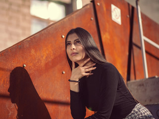 stylish girl model posing sitting on the steps of the building