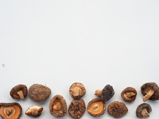 Dried Shiitake Mushrooms on white wooden table, is an edible mushroom native to East Asia, Mushroom is cultivated and consumed in many Asian countries. It is considered a medicinal mushroom.