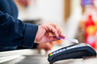 © Sondem - Close up of cashier is using contactless credit card pos terminal to getting the payment.