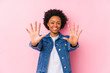Young african american woman against a pink backgroound isolated showing number ten with hands.