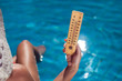 Leinwandbild Motiv Woman holding thermometer on the pool background. Hot weather and summer concept