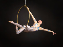 A Slender,dark-haired Girl - An Air Acrobat In A White And Blue Suit, Performs Exercises In An Air Ring.