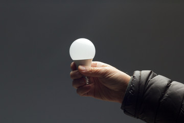 Energy saving light bulb in the hand of an adult