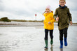 © spass - Two happy children running and jumping on water of Baltic sea in rubber boots