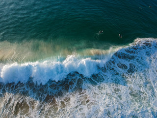 aerial view from a big wave crashing in a beach. Drone view