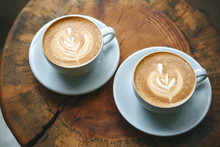 Two Cups Of Aromatic Coffee Cappuccino Or Latte On A Wooden Table. Tasty Morning Drinks.