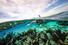 A Woman Snorkeling In Blue Water