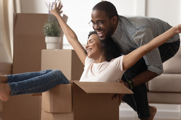 Wall Mural - Happy black family couple having fun with carton boxes.