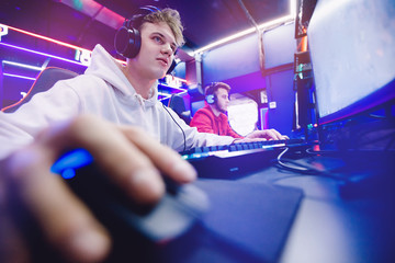 Professional gamer playing tournaments online video games computer with headphones, red and blue