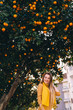 © Ivan - girl walking on the streets in dress. trees with oranges. city.
