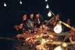 © HBS - Camp on the hill. Group of young friends having picnic with bonfire. They drink beer