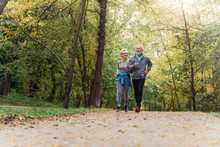 Cheerful Active Senior Couple Jogging In The Park. Exercise Together To Stop Aging.