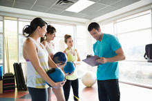Women Talking With Instructor In Fitness Class