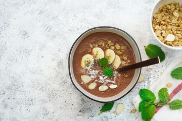 Chocolate smoothie bowl topped with fruits and seeds/ Healthy breakfast concept