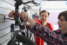 Father And Son Repairing Bicycle In Garage