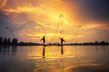 Asian Fishermen On Boat Fishing At Lake, Thailand Countryside