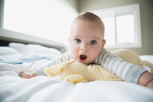 Portrait Of Yawning Baby On Bed