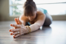 Woman In Yoga Childs Pose With Hands Clasped