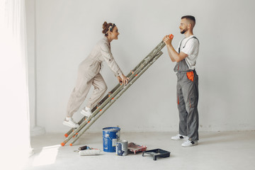 Family repairs. Couple at home. Woman in a overalls