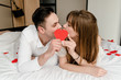 © Anastasia - man and woman in bed with heart shape in hands
