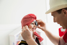 Father Adjusting Eye Patch On Daughter Pirate Costume