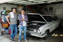 Portrait Father And Son Restoring Vintage Car Garage