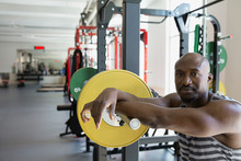 Portrait Confident Man Leaning On Barbell At Gym