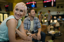 Smiling Young Woman With Friends At Bowling Alley